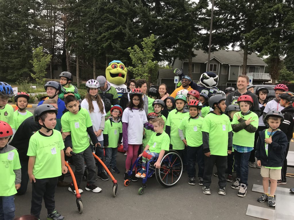 Lynnwood Times photo by Luke Putvin. NASCAR driver Molly Helmuth, Blitz of the Seattle Seahawks and Webbly of the Everett Aquasox with participants at the Lynnwood Rotary Challenge Race on June 22.