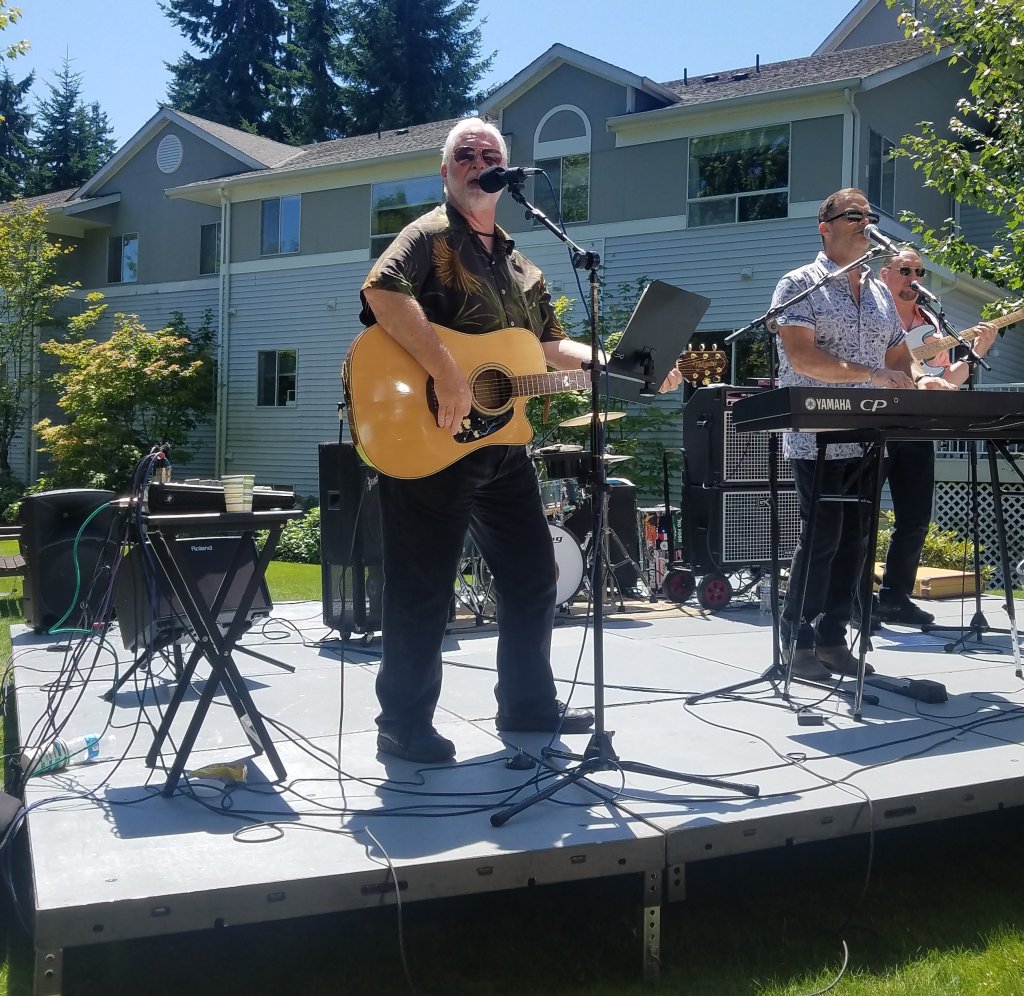 Lynnwood City Council candidate and lead vocalist for the band GenRASun, Jim Smith, providing entertainment at the car show.